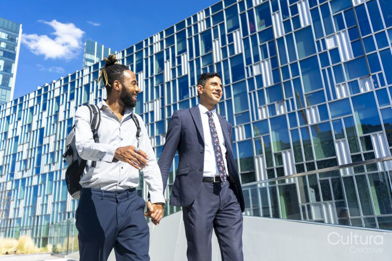 Businessmen couple holding hands in business district