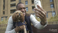 Man with dog using smartphone to take selfie