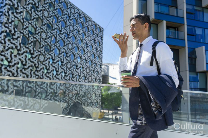 Businessman walking in business district and talking on phone