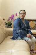 Portrait of young woman with down syndrome sitting on sofa at home