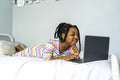 Girl lying on bed using laptop