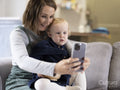 Mother and daughter sitting on sofa and taking selfie