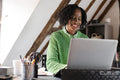Smiling businesswoman working on laptop in office