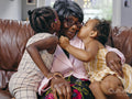 Great granddaughters kissing great grandmother