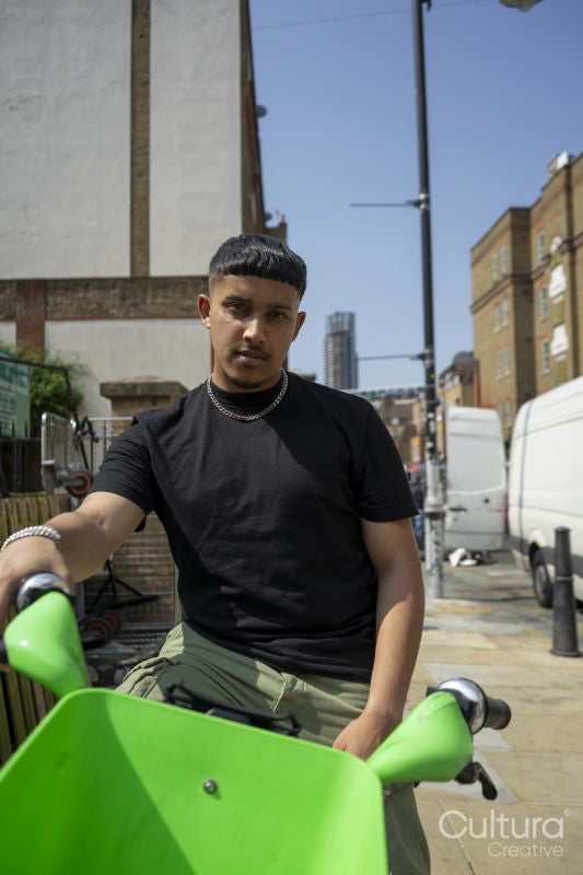 Man sitting on bike in city and looking at camera