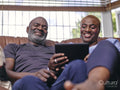Couple sitting on sofa and using digital tablet