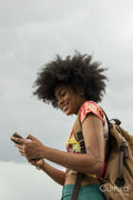 Young woman with backpack using phone