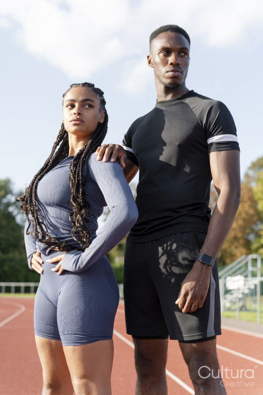 Portrait of couple of athletes standing at sports track