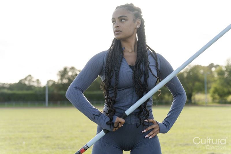Portrait of confident female athlete holding javelin