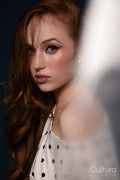 Studio portrait of a woman in a polka dot top with windswept hair