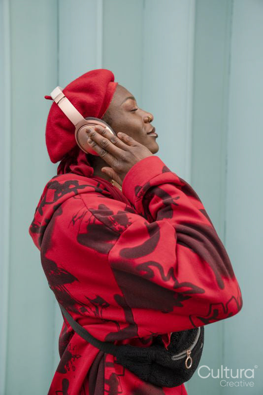 Smiling young woman wearing red listening to music