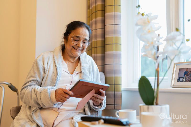 Senior lady sitting with photography at nursing home