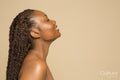 Profile of smiling shirtless woman with braided hair