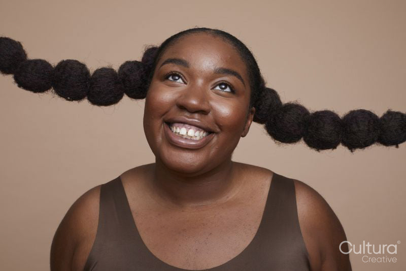 Studio shot of smiling young woman with braided hair