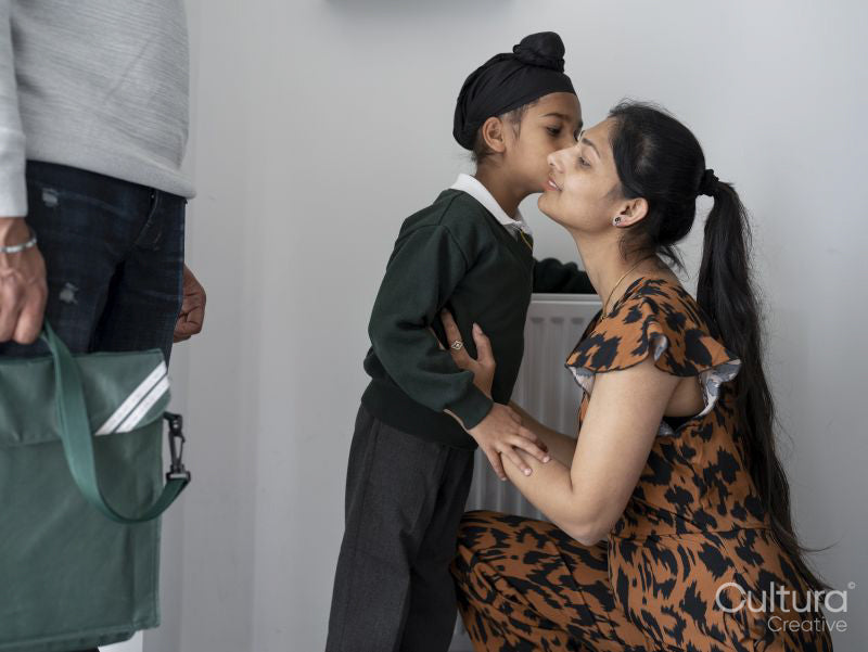 Boy kissing mother on cheek before going to school