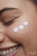 Close-up of young woman applying face cream