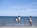 Father with daughters standing on promenade and looking at sea