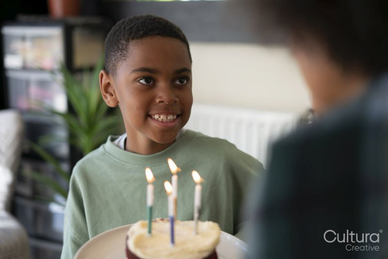 Mother and son celebrating birthday with birthday cake