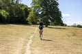 Young woman hiking in countryside, rear view