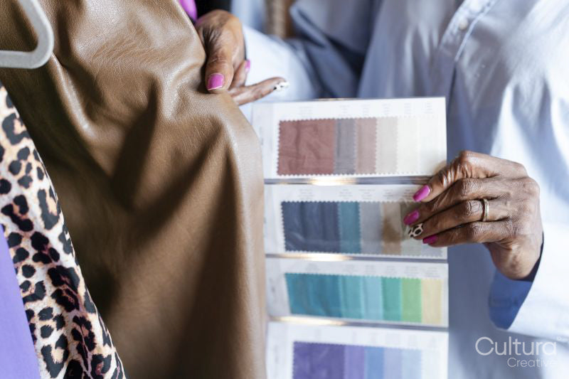 Close-up of fashion designer comparing color swatches with clothing