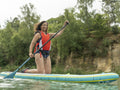 Smiling woman paddleboarding on lake