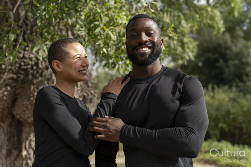 Portrait of smiling athletic couple in park
