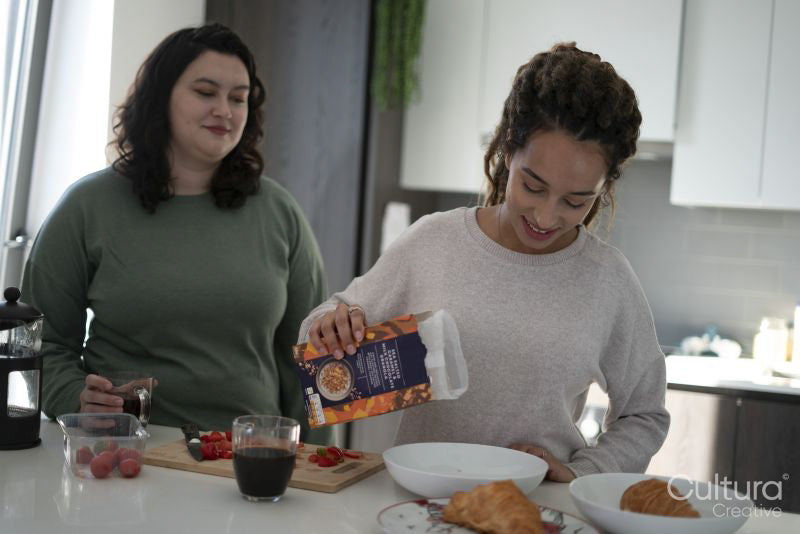 Two women preparing breakfast in kitchen
