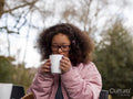 Girl drinking hot drink outdoors