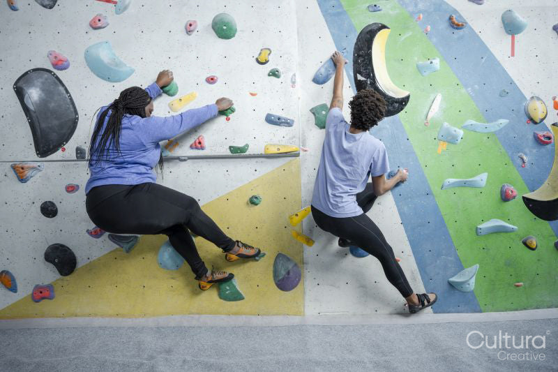 Mother and daughter climbing on bouldering wall