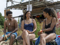 Smiling friends eating on beach on sunny day