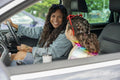 Smiling mother and daughter sitting in car
