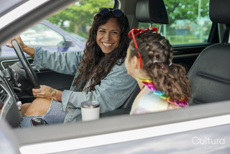 Smiling mother and daughter sitting in car