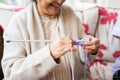 Senior woman knitting in nursing home