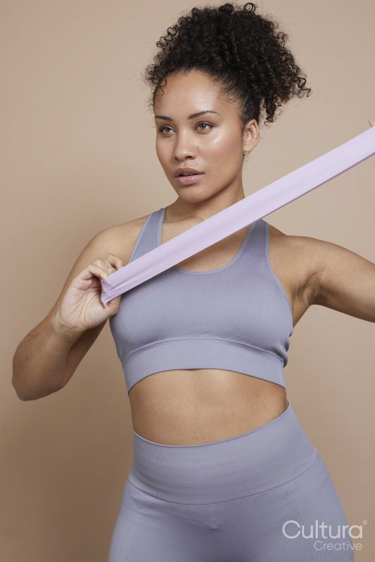 Studio portrait of athletic woman exercising with resistance band