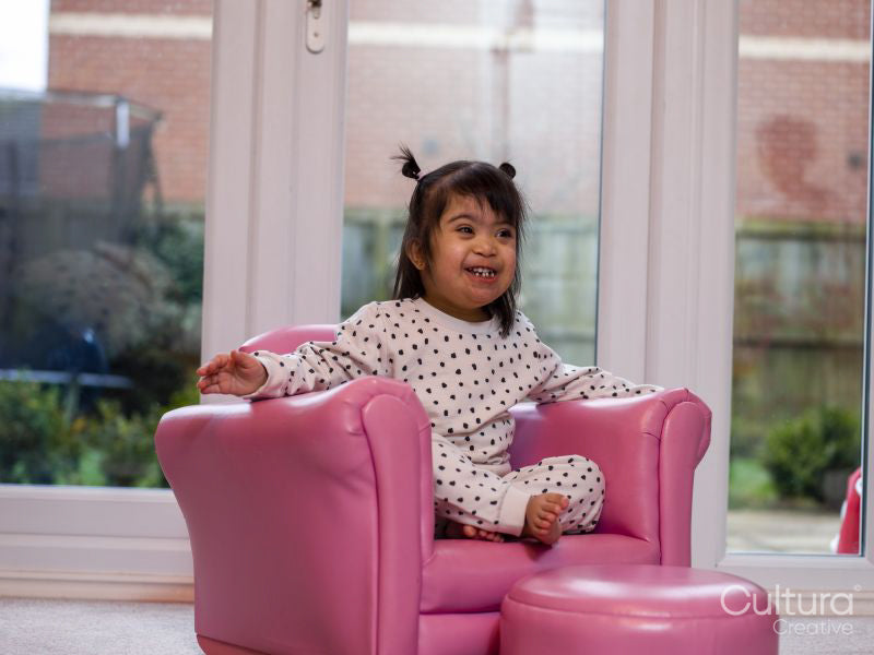 Girl sitting in pink armchair