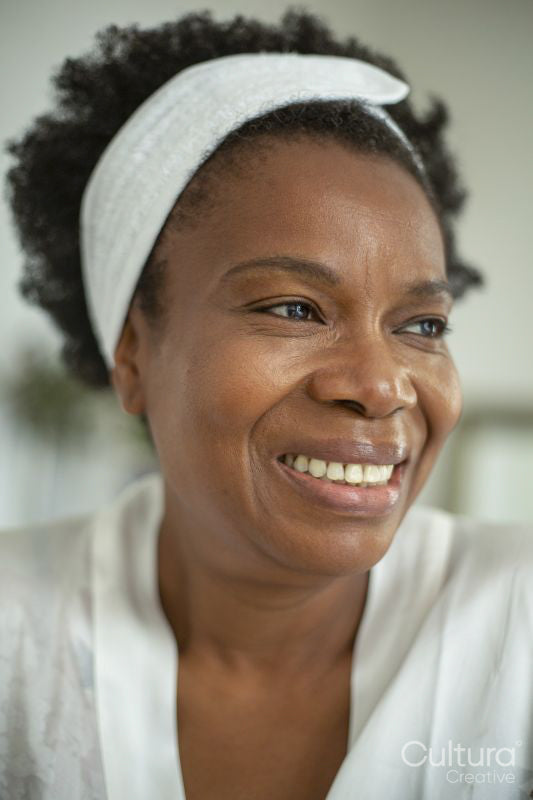 Close-up of smiling woman wearing white headband and bathrobe
