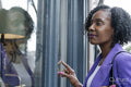 Thoughtful woman looking through store window