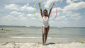 Portrait of teenage girl with hula hoops on beach