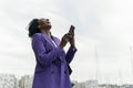 Woman laughing while using smart phone in city