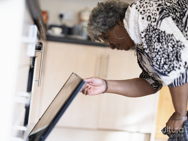 Mature woman opening oven door