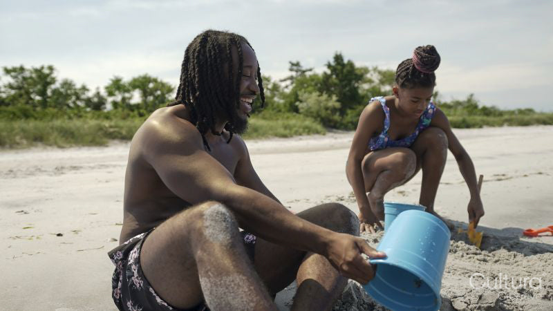 Father and daughter playing on sandy beach
