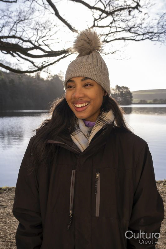 Smiling young woman in knit hat at lake