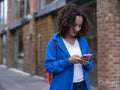 Smiling woman using smart phone on street