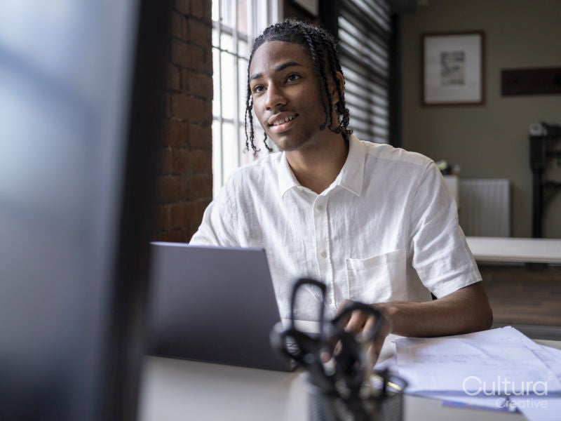 Teenage boy using laptop in office