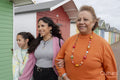 Grandmother, mother and granddaughter walking by beach hut