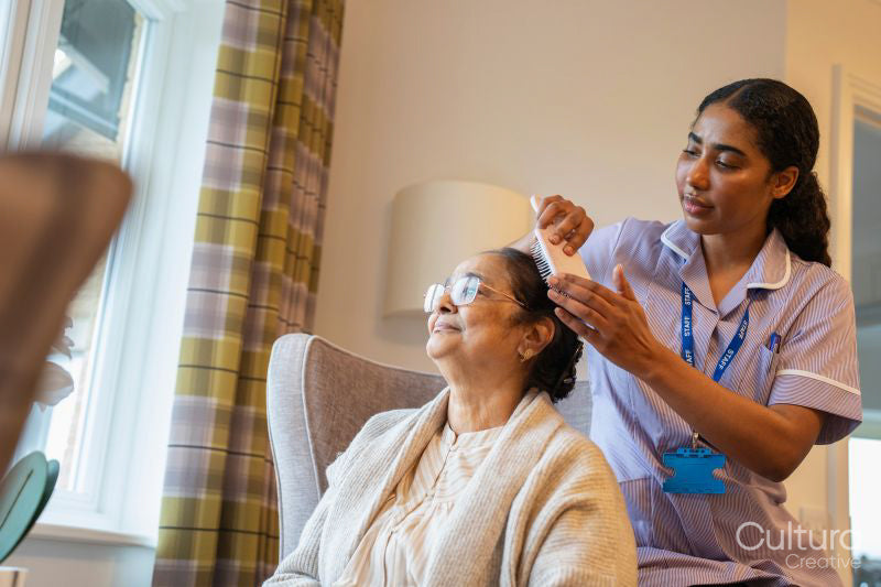 Nurse brushing hair of senior lady at nursing home