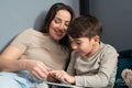 Mother and son reading in bedroom