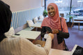 Smiling female customer paying with smart phone in cafe