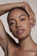 Portrait of young woman with hand on head