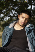 Portrait of man in jacket sitting outdoors